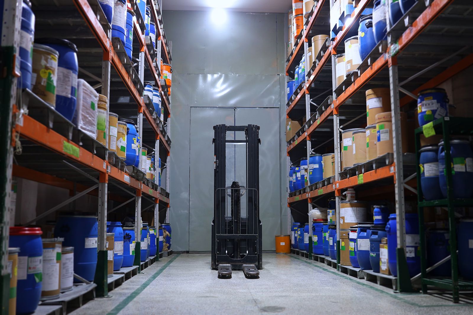 Pharmaceutical warehouse aisle with shelving and a forklift
